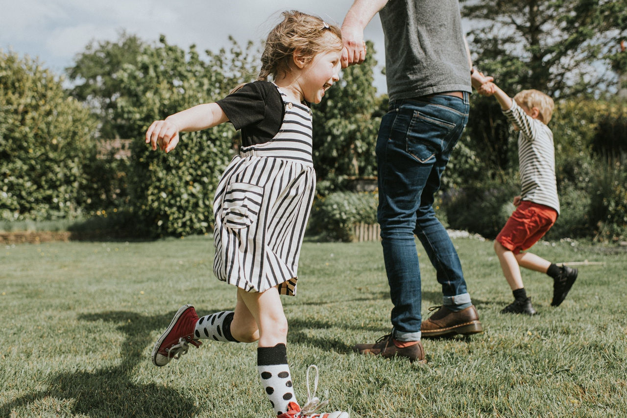 Vater spielt mit seinen beiden Kindern im Garten