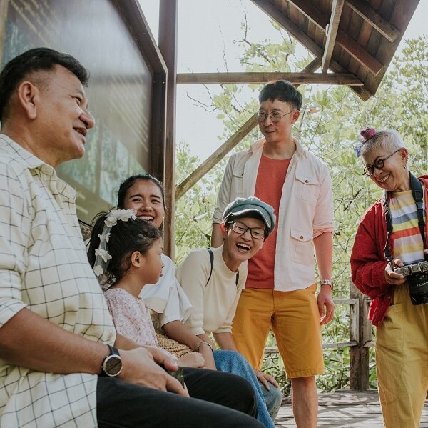 Thai large family laughing with a question that little girl asking about a mangrove forest while they visit