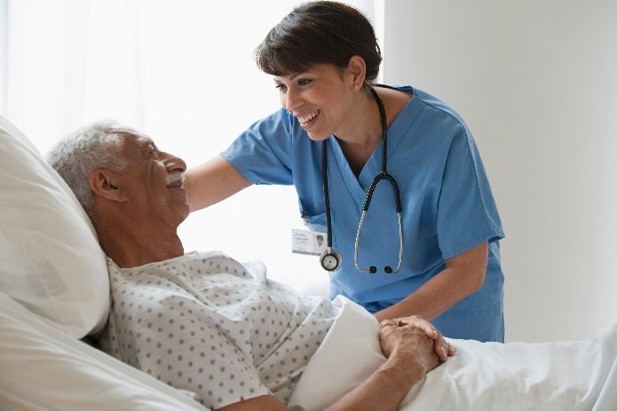 Krankenschwester kümmert sich um einen genesenden älteren männlichen Patienten