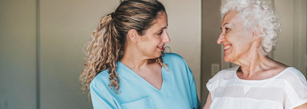 young nurse standing close to female senior patient