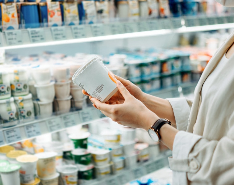 shopper reading label on yogurt