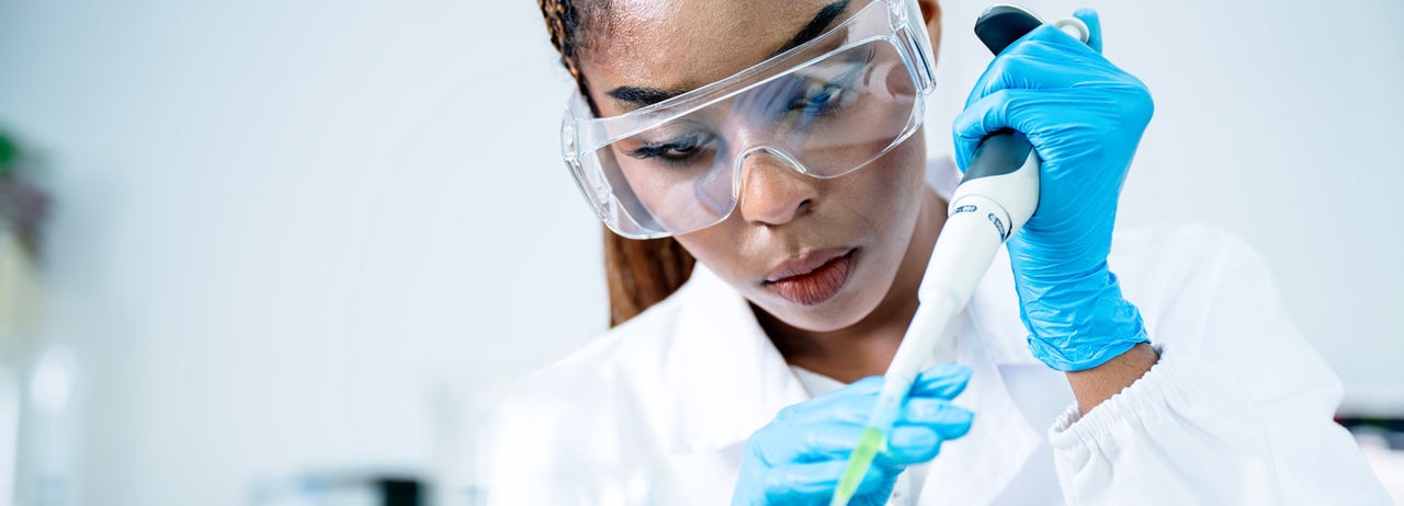 Healthcare research can improve medicine development and safety. Front view of a laboratory scientist using an automatic pipette to analyze the medical sample in a laboratory.