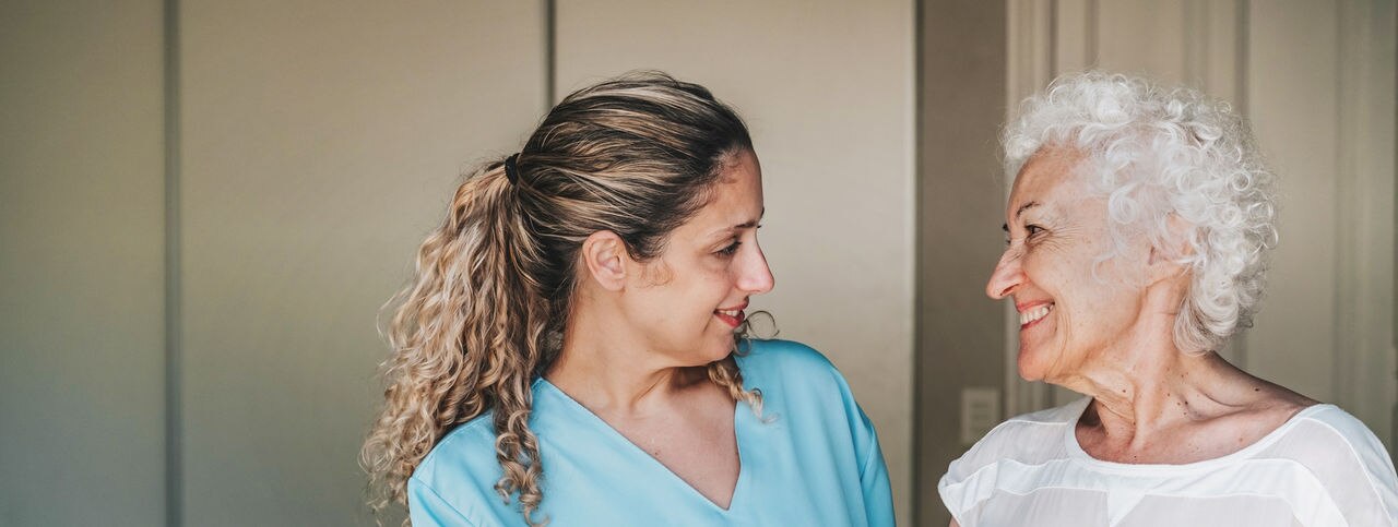 young nurse standing close to female senior patient