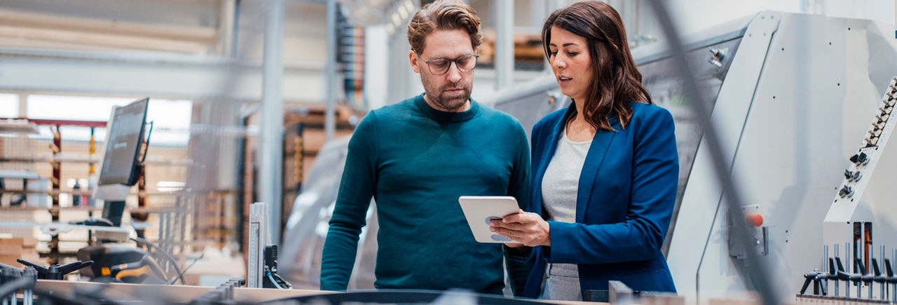 Engineers discussing over tablet computer in industry