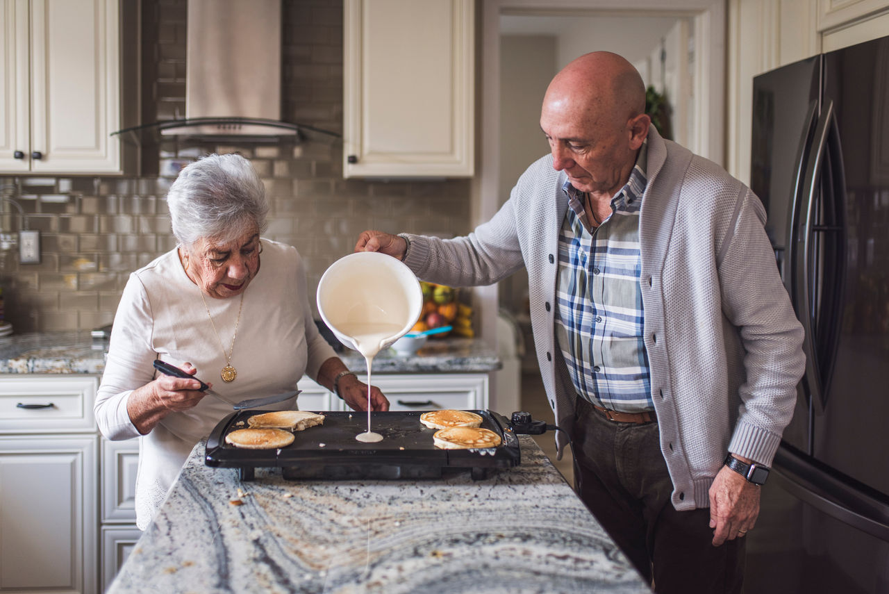 Great grandma cooking pancakes with husband
