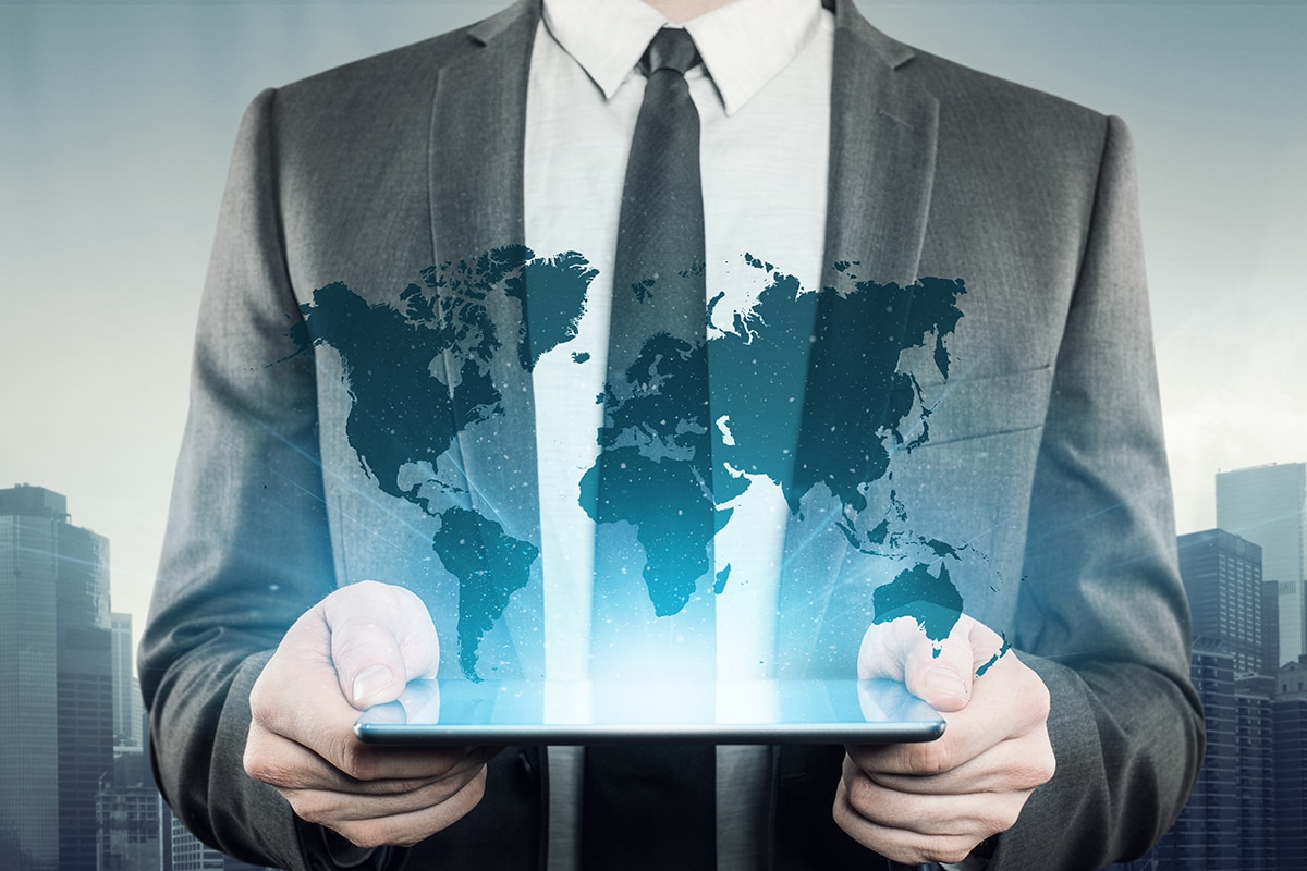 Businessman holding a tablet which glows world map