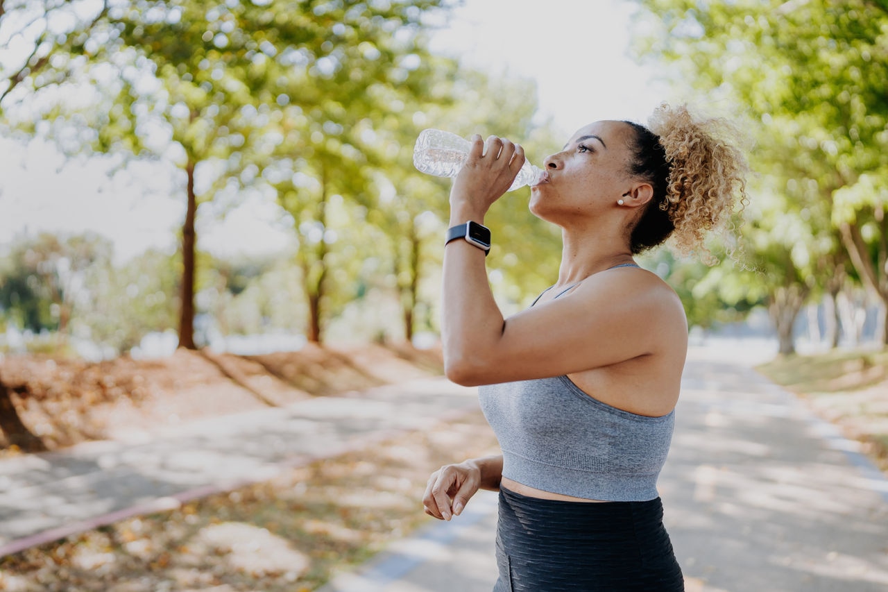 Fitness runner woman drinking water