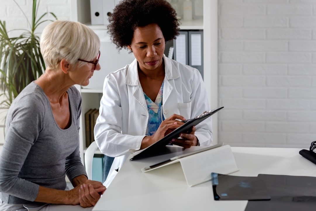 woman with her doctor looking at results on a chart.