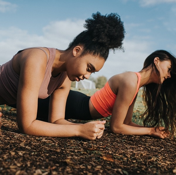 Three fit woman in bootcamp. They put in a lot of effort by planking side-by-side. Space for copy.