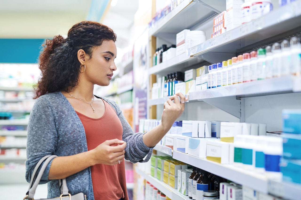 Shot of a young woman browsing the shelves of a pharmacy