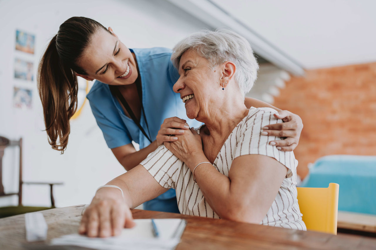 Nurse hugging senior patient