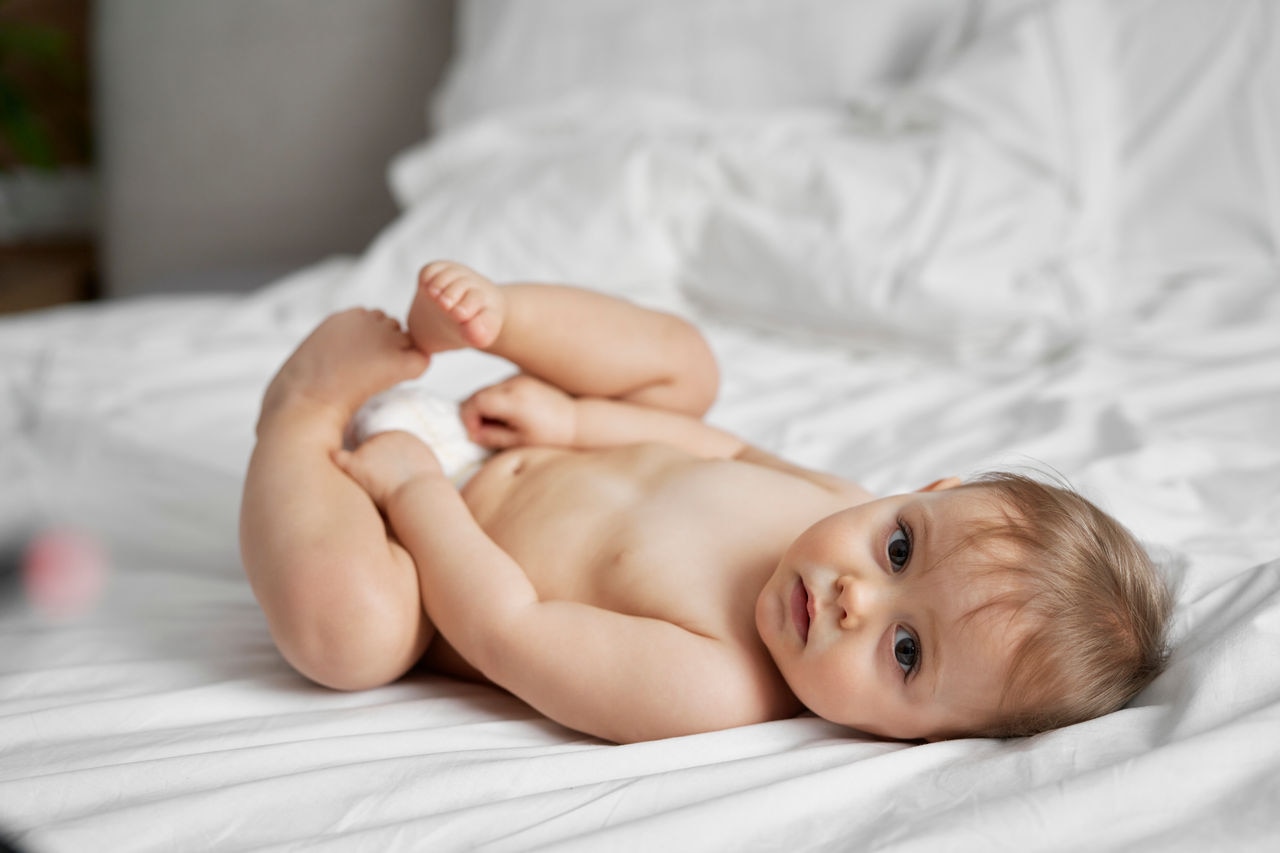 Cute little girl after the bath lying on the bed