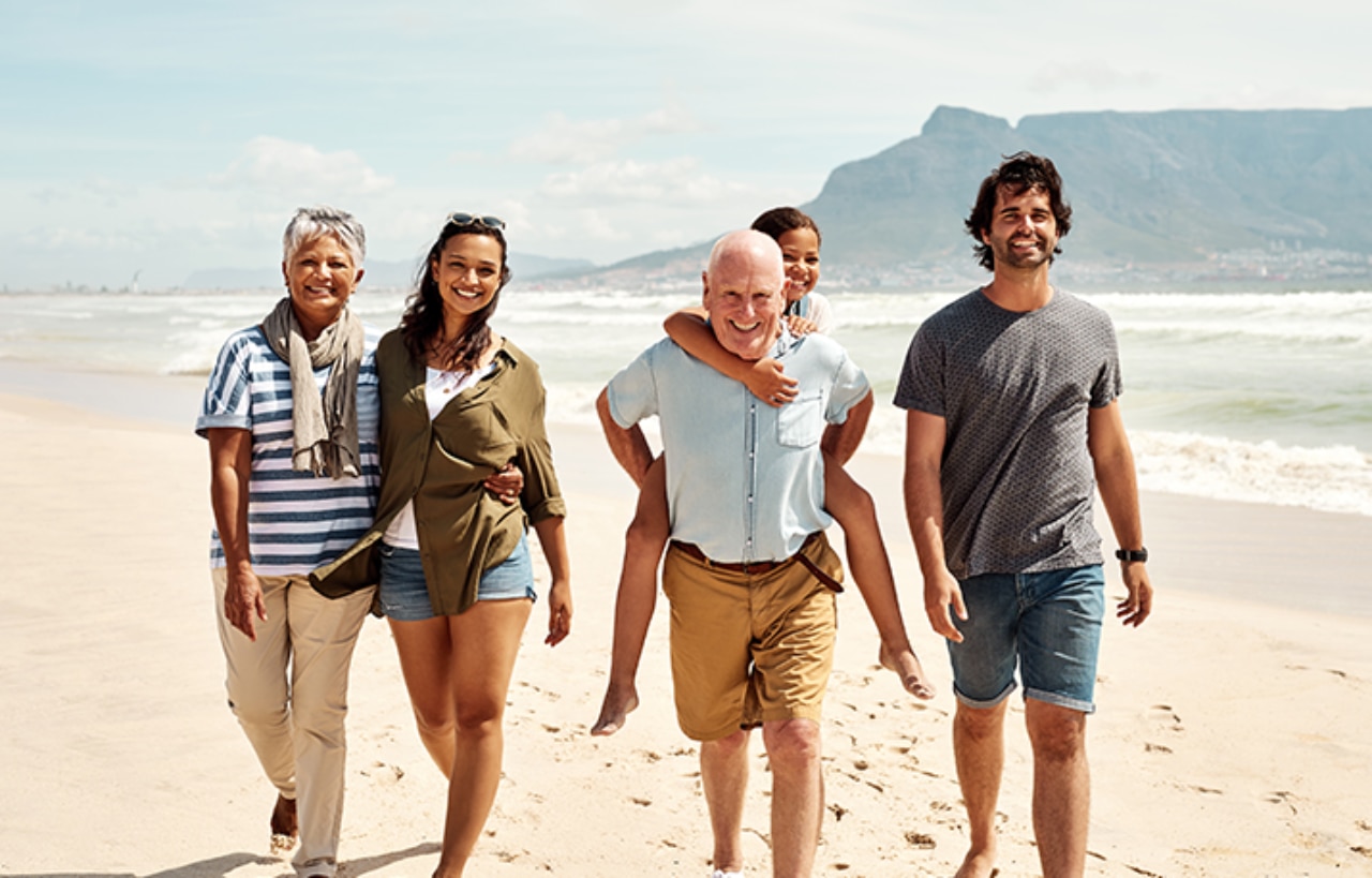A happy family walking together in a beach shore 