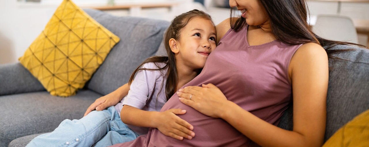 Pregnant mother and her daughter spending time together at home.