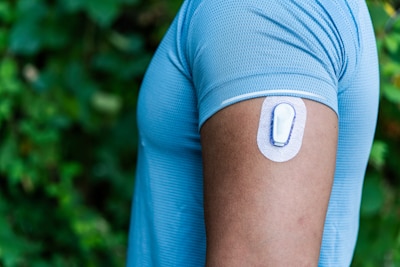Athlete with Continuous Glucose Monitor Transmitter Adhered to Arm