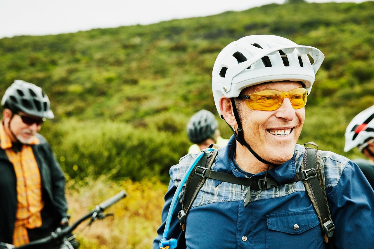 Portrait of smiling senior man hanging out with friends before early morning mountain bike ride