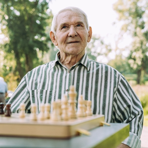 Group of senior friends playing chess game at the park. Lifestyle concepts about seniority and third age