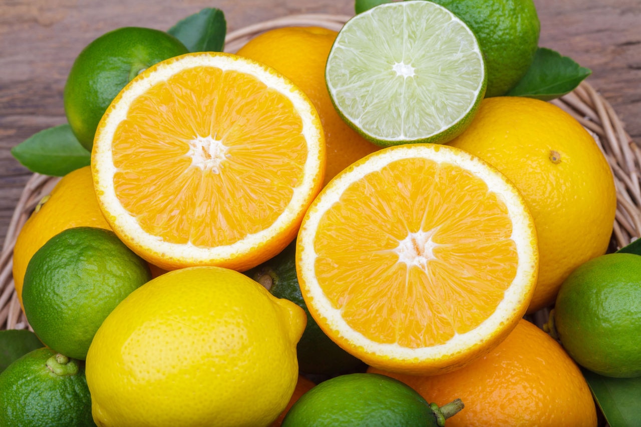 Mix of fresh citrus fruits in basket on  wood