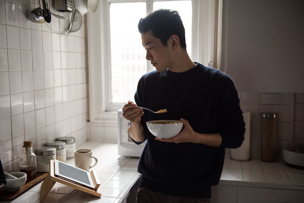 Man using digital tablet while having breakfast at home; Shutterstock ID 1895384206; purchase_order: Masterbrand - Loop 4; job: ; client: ; other: 