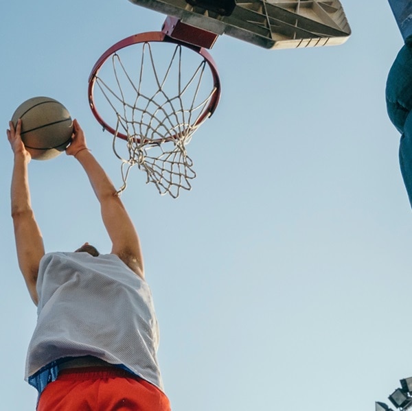 Man jumping for basketball hoop