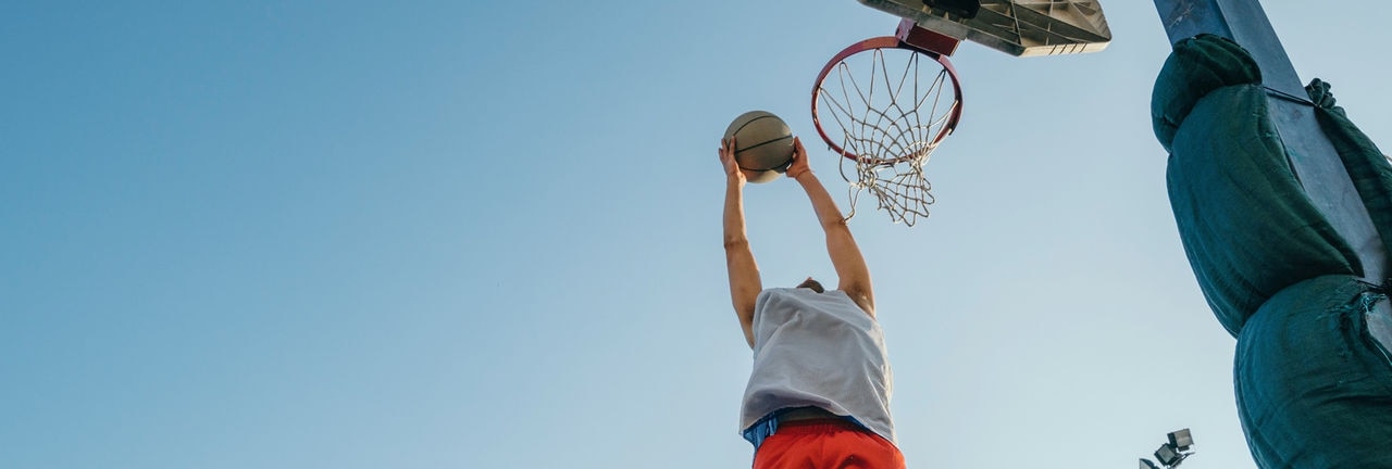 Man jumping for basketball hoop