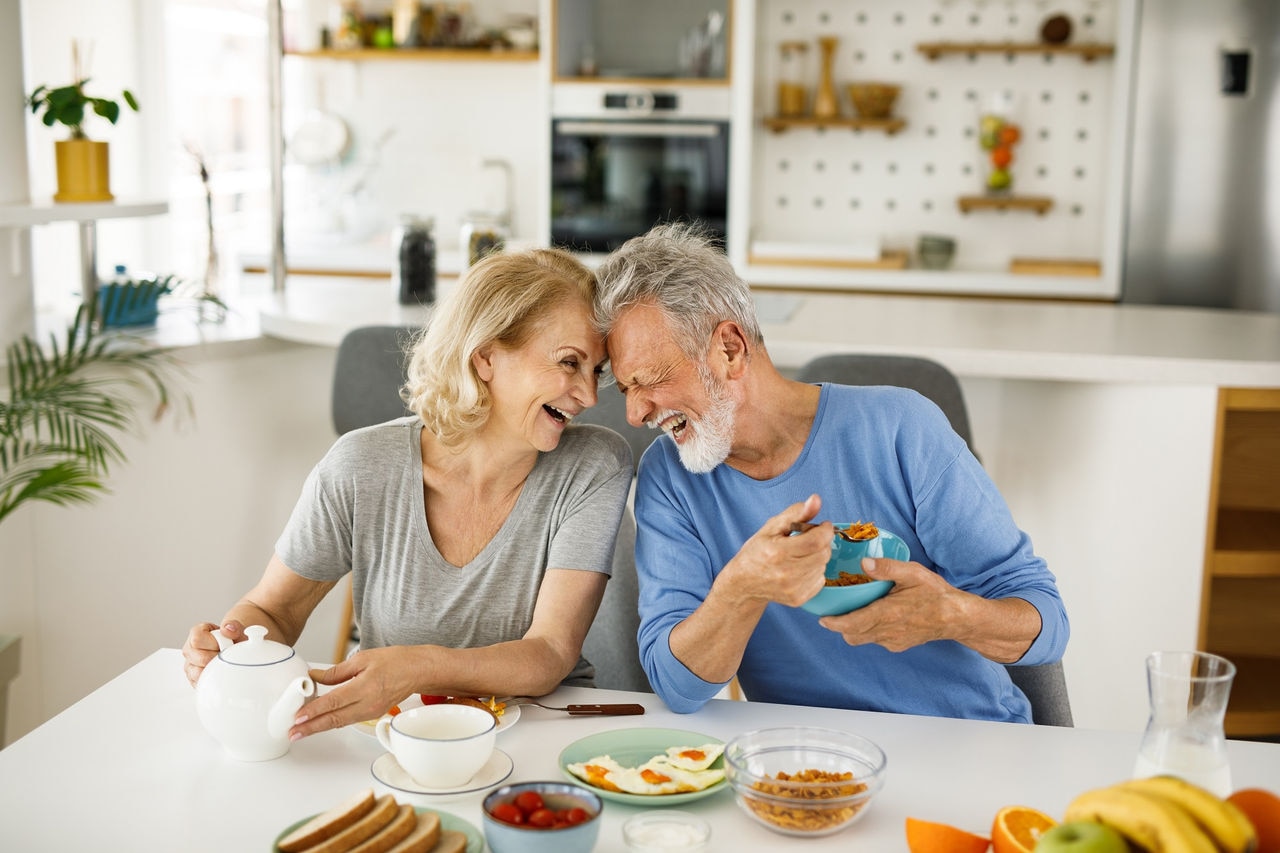Happy senior couple having a breakfast together at home