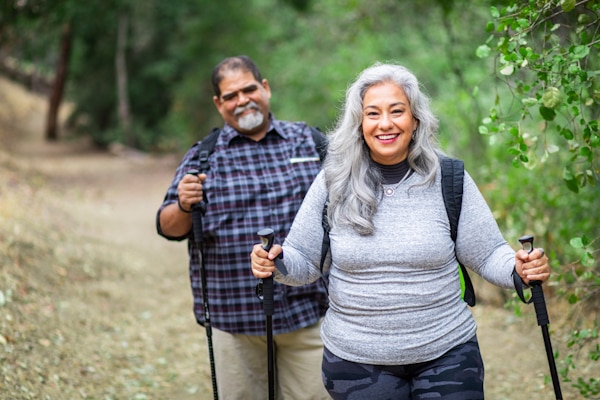 A senior mexican couple hiking in the woods.