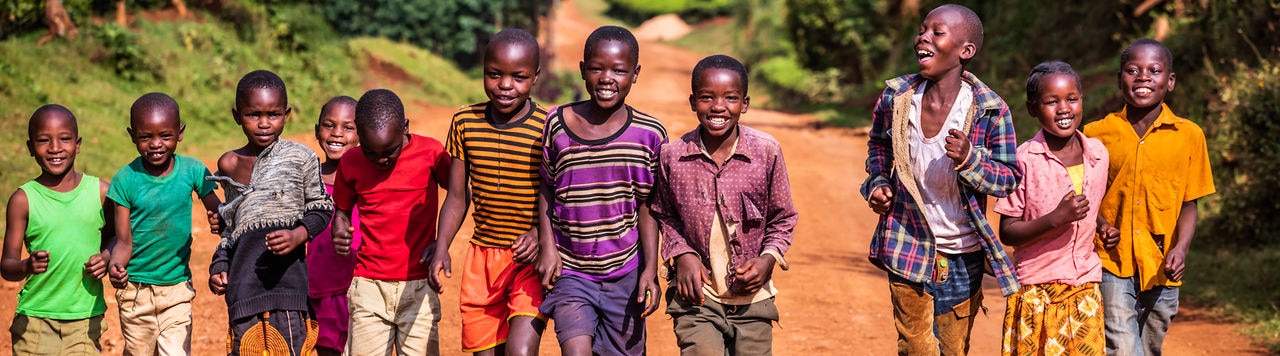 Group of colorful dressed, happy African children running in Central Kenya, East Africa
