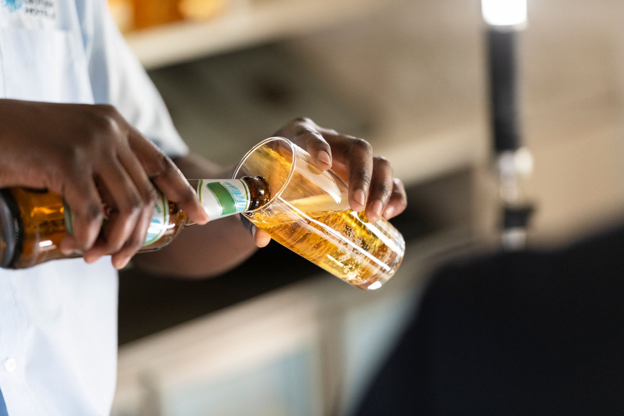 Close up barman pouring beer into glass