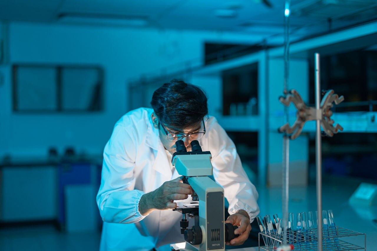 A scientist studying a microscope