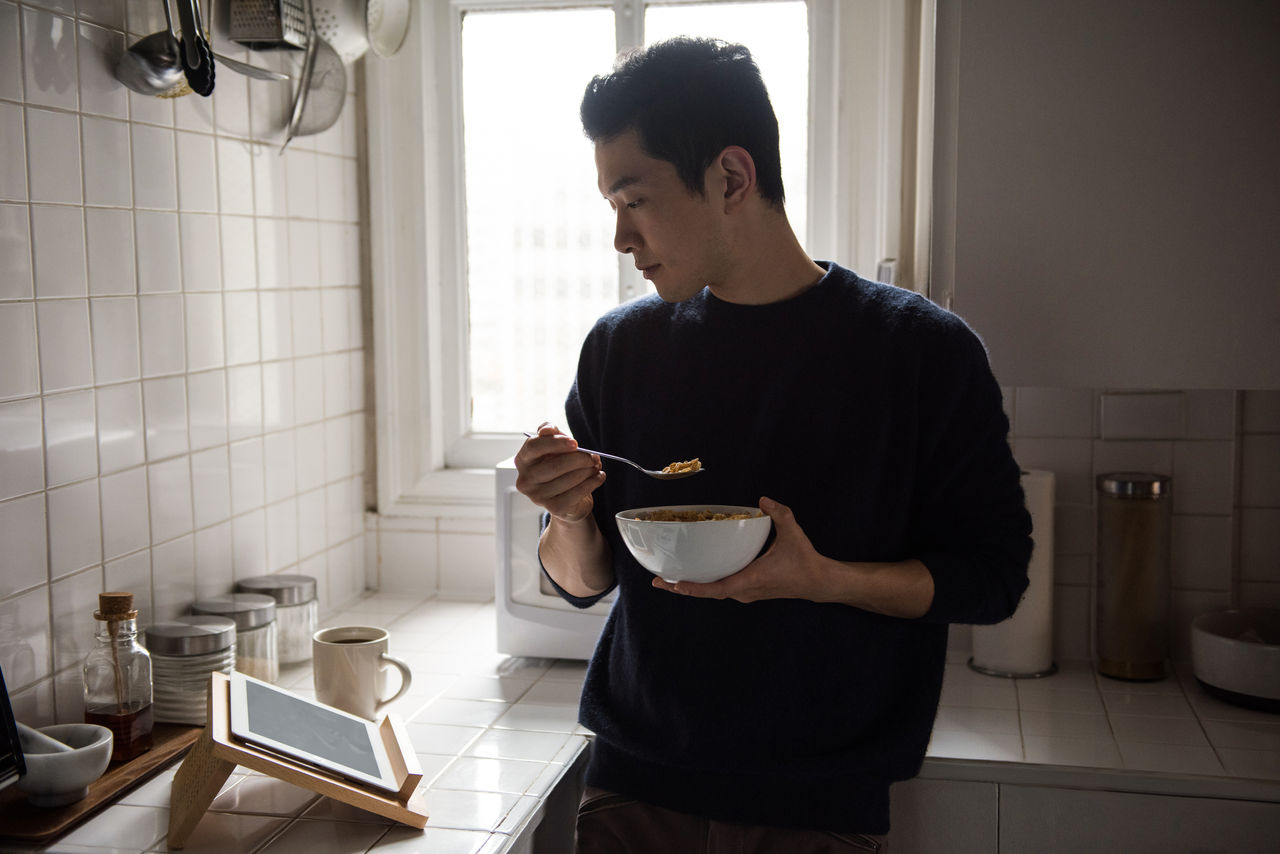 Man using digital tablet while having breakfast at home; Shutterstock ID 1895384206; purchase_order: Masterbrand - Loop 4; job: ; client: ; other: 
