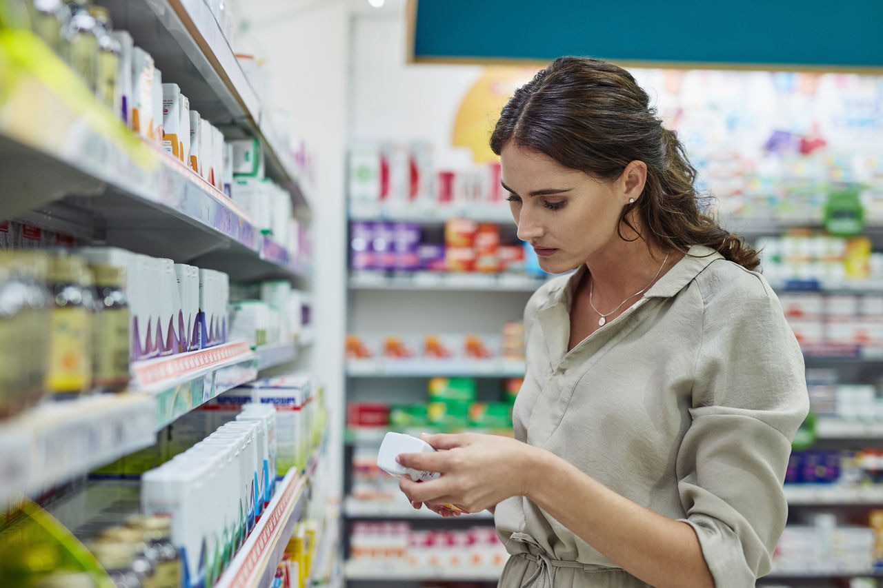 Shot of a young woman browsing the shelves of a pharmacy
