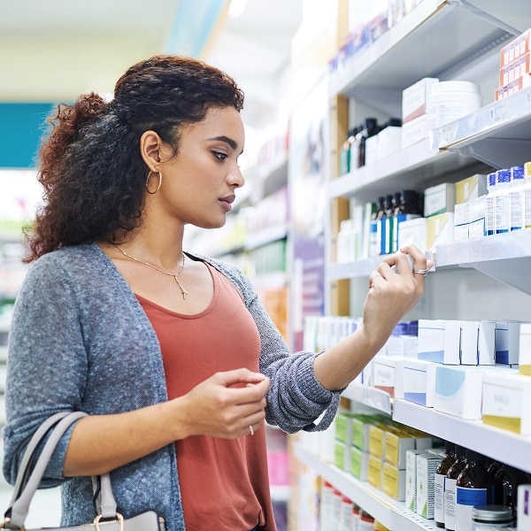 Shot of a young woman browsing the shelves of a pharmacy