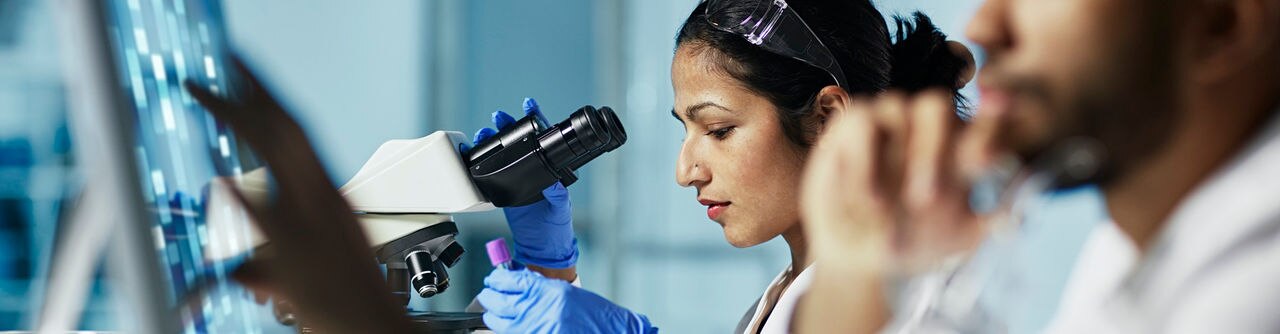 Scientist Working on Computer In  Modern Laboratory
NOTE TO INSPECTOR: all graps, dna models, charts are made by me