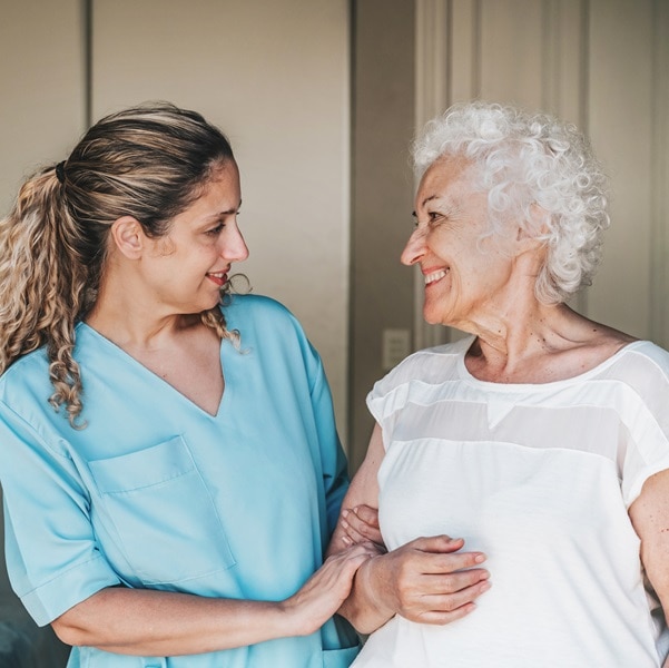young nurse standing close to female senior patient
