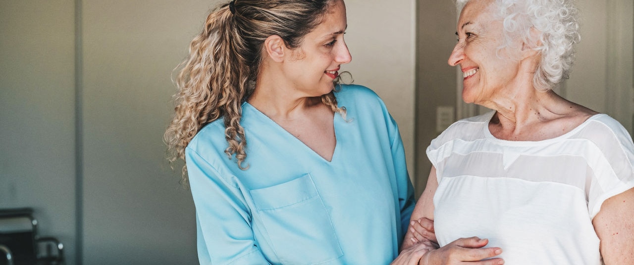young nurse standing close to female senior patient