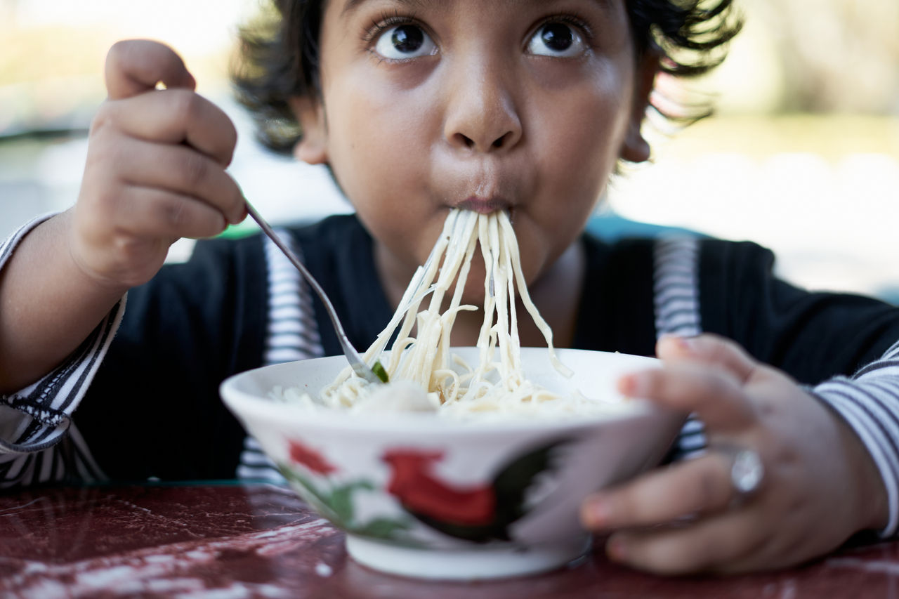 Little cute girl enjoy eating noodle at Street food market; Shutterstock ID 1745000681; purchase_order: -; job: -; client: -; other: -
