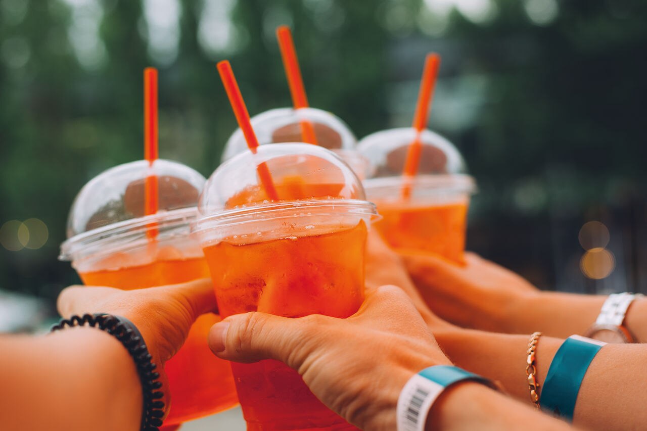 Woman's hands toasting with Spritz cocktails on the music festivel