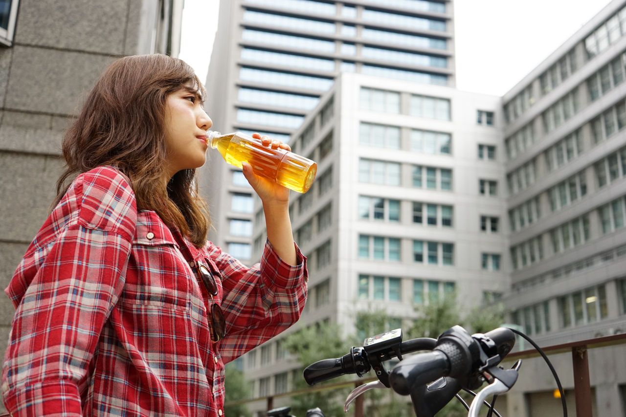 Young Japanese Woman drinking water on a bike