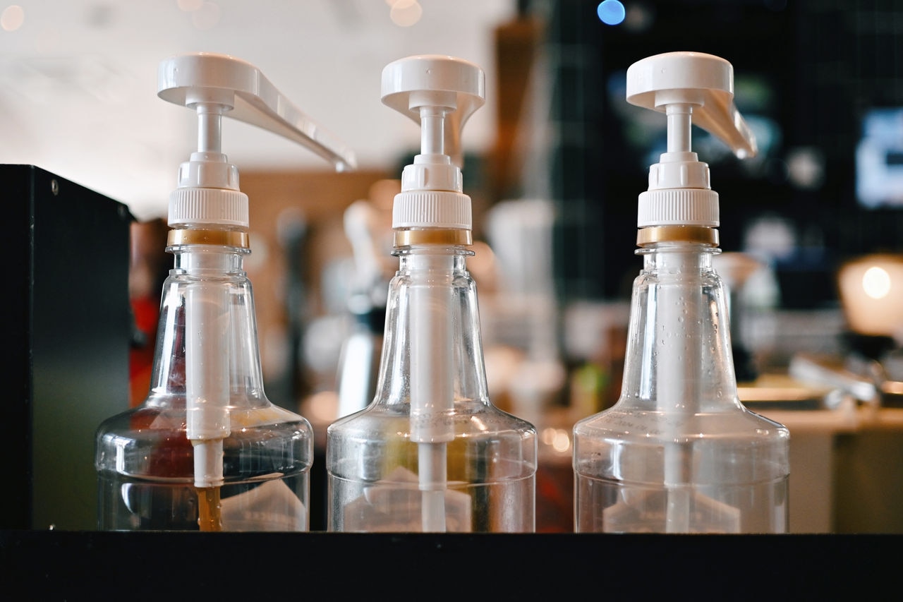 close up bottle pump with syrup in cafe, food and drink business