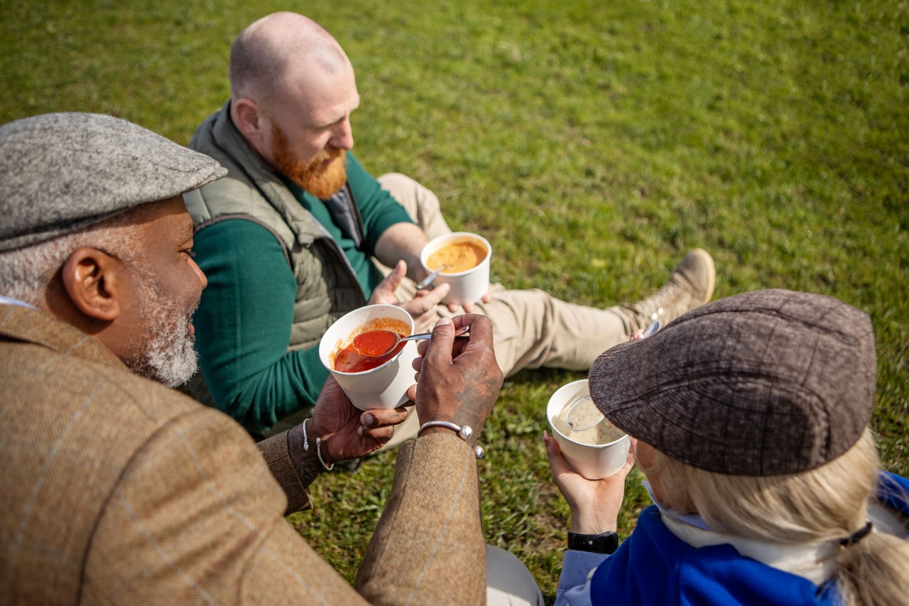 Three diverse friends enjoying healthy food soup outdoors in Holland on a sunny spring day