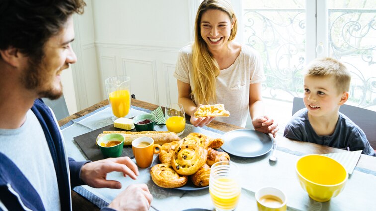 Happy family having breakfast together at home.