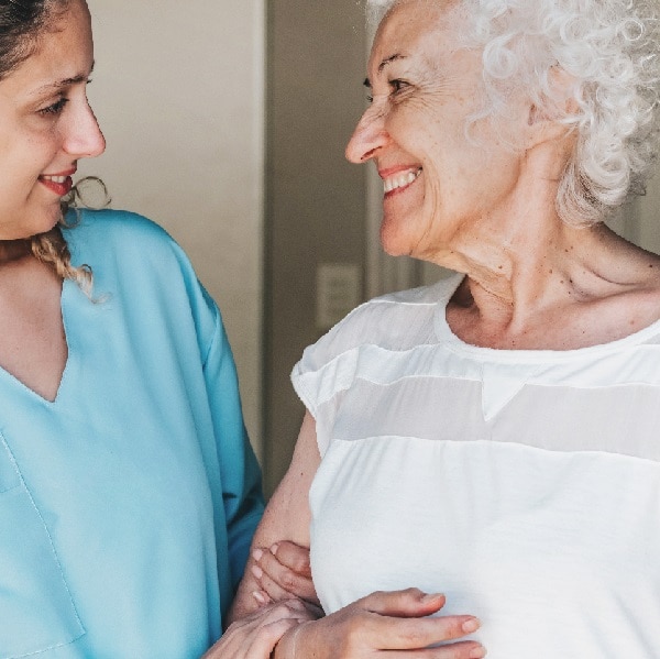 young nurse standing close to female senior patient