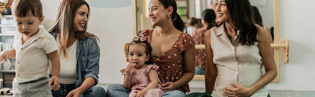 Mothers talking while their babies playing in the playroom