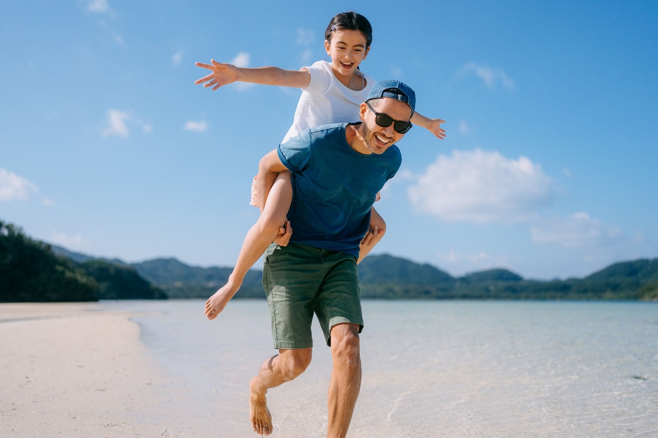 Father and his young daughter having a good time on tropical beach, Ishigaki Island of Yaeyama Islands, Okinawa, Japan