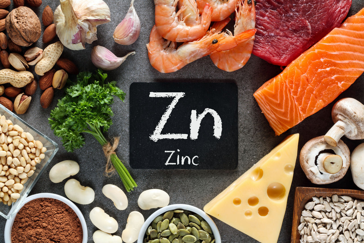 Foods High in Zinc as salmon, seafood-shrimps, beef, yellow cheese, parsley leaves, mushrooms, cocoa, pumpkin seeds, garlic, bean, almonds, pine nut. Top view