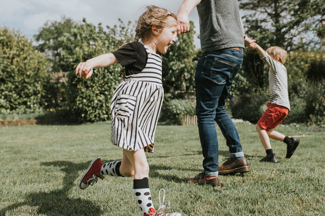 Vader speelt met zijn twee kinderen in de achtertuin
