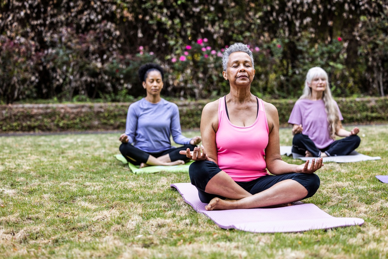 Senior women taking a yoga class in beautiful garden