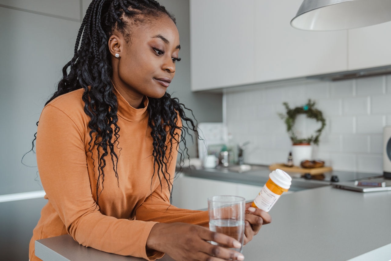 Photo of a young woman preparing to take medicine