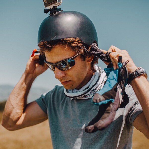 A paraglider prepares a helmet